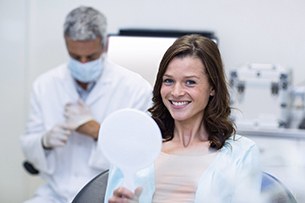 A woman smiling while visiting an implant dentist.